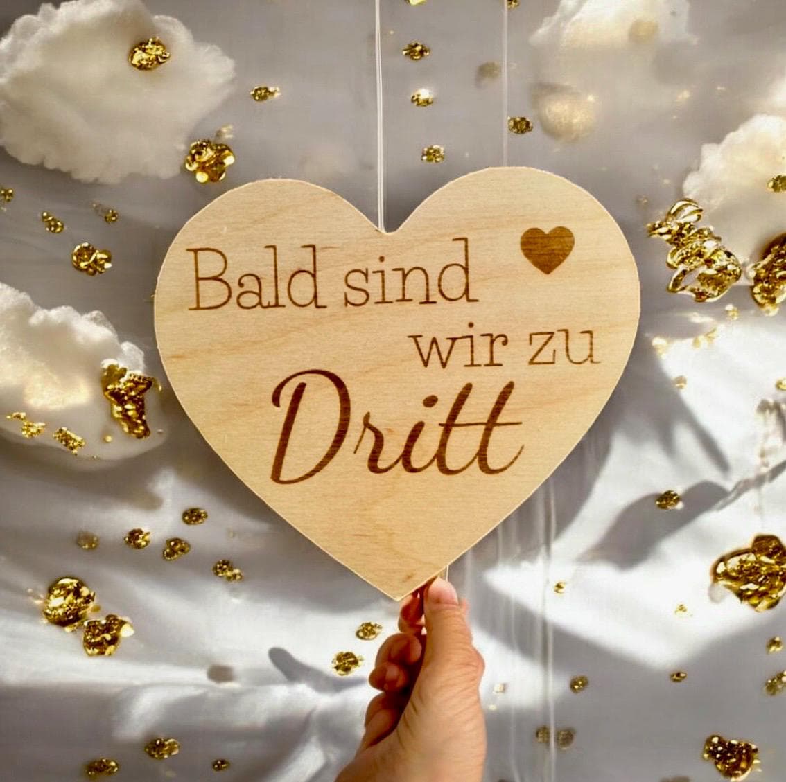 Herz aus Holz mit der aufschrift "Bald sind wir zu dritt" zum Scchwangerschaft mitteilen Schild Das Glückswerk