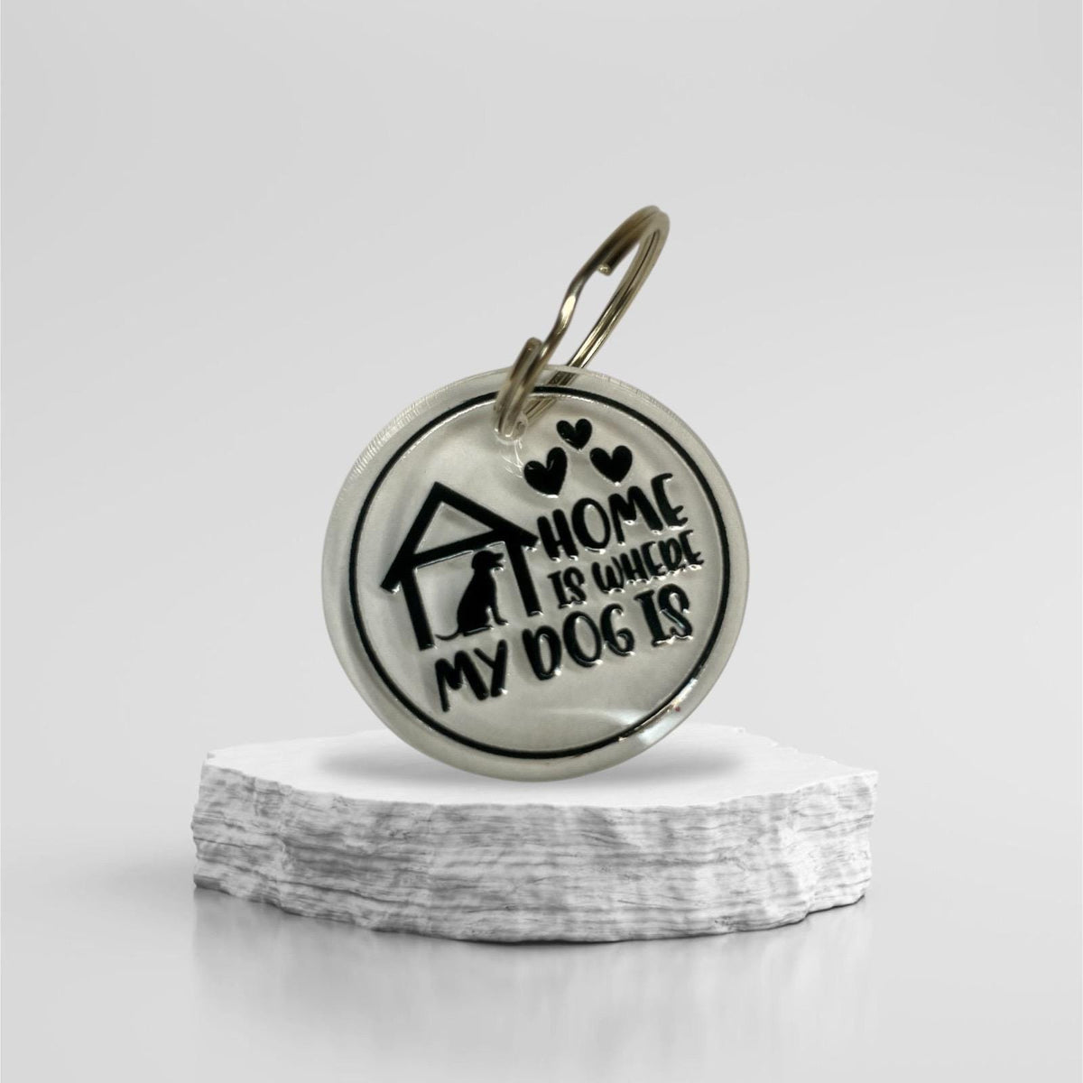 Acryl-Schlüsselanhänger mit Spruch "Home is where my dog is", stilvoll arrangiert auf einem hellen Untergrund, Hundeliebhaber Geschenk.