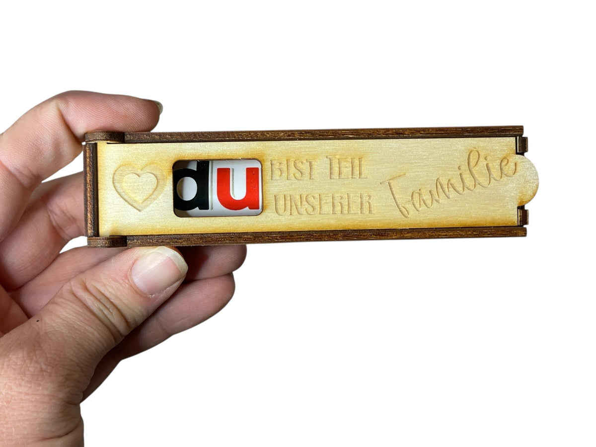 Schokoriegelhülle Holz mit Buchstabenklötzchen „DU“, Nahaufnahme