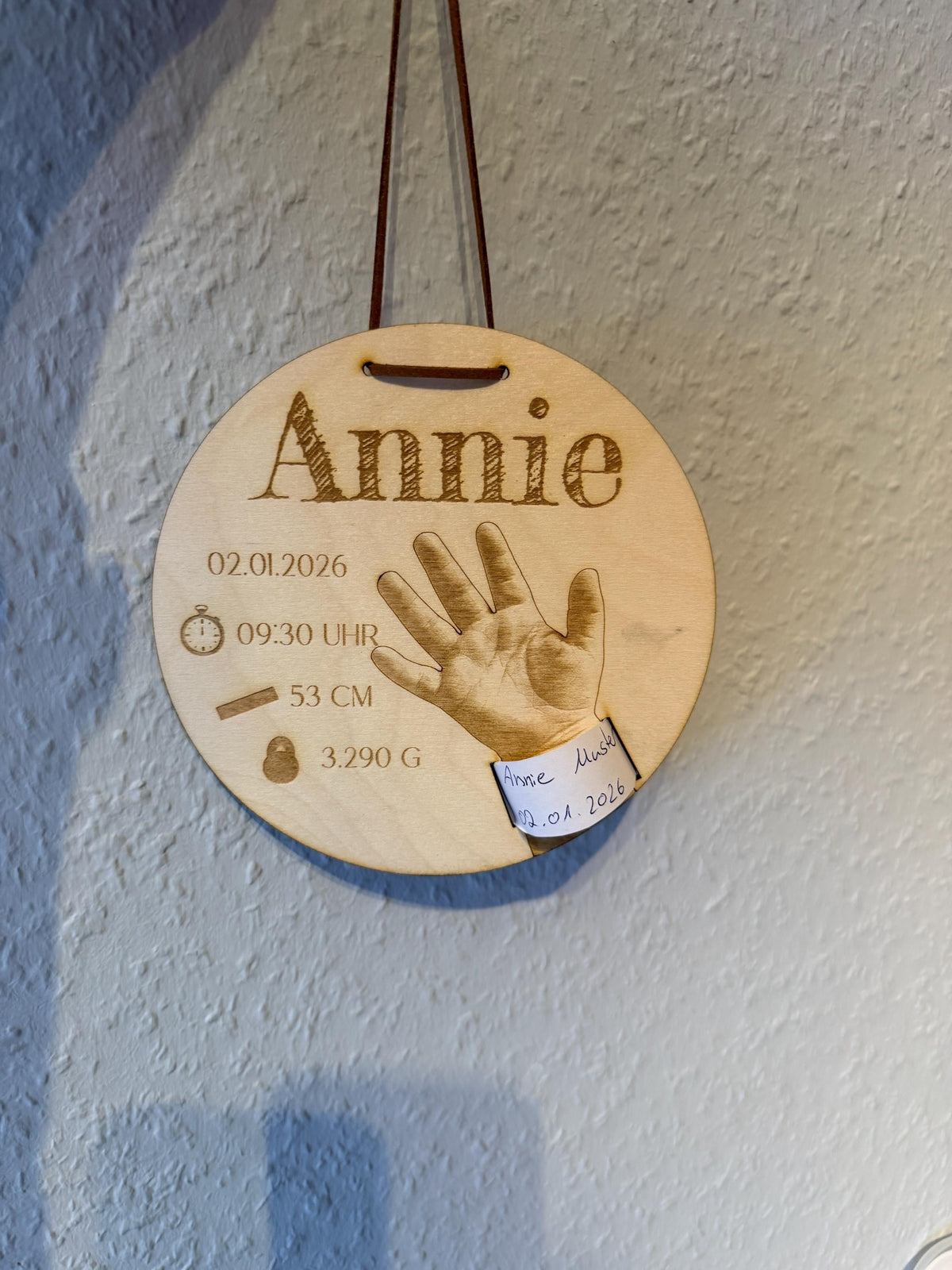 Geburtsarmband-Halter aus Holz an der Wand hängend, Nahaufnahme